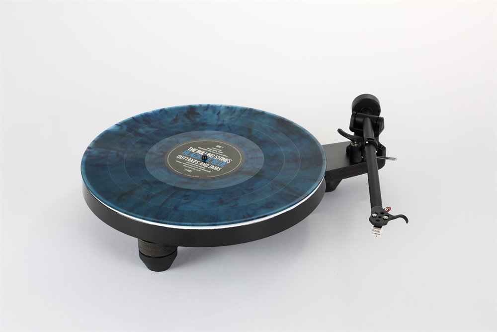 La Rega Replay en noir mat vue de face, un disque bleu marbré sur le plateau, le bras RB110 avec la cellule Carbon.